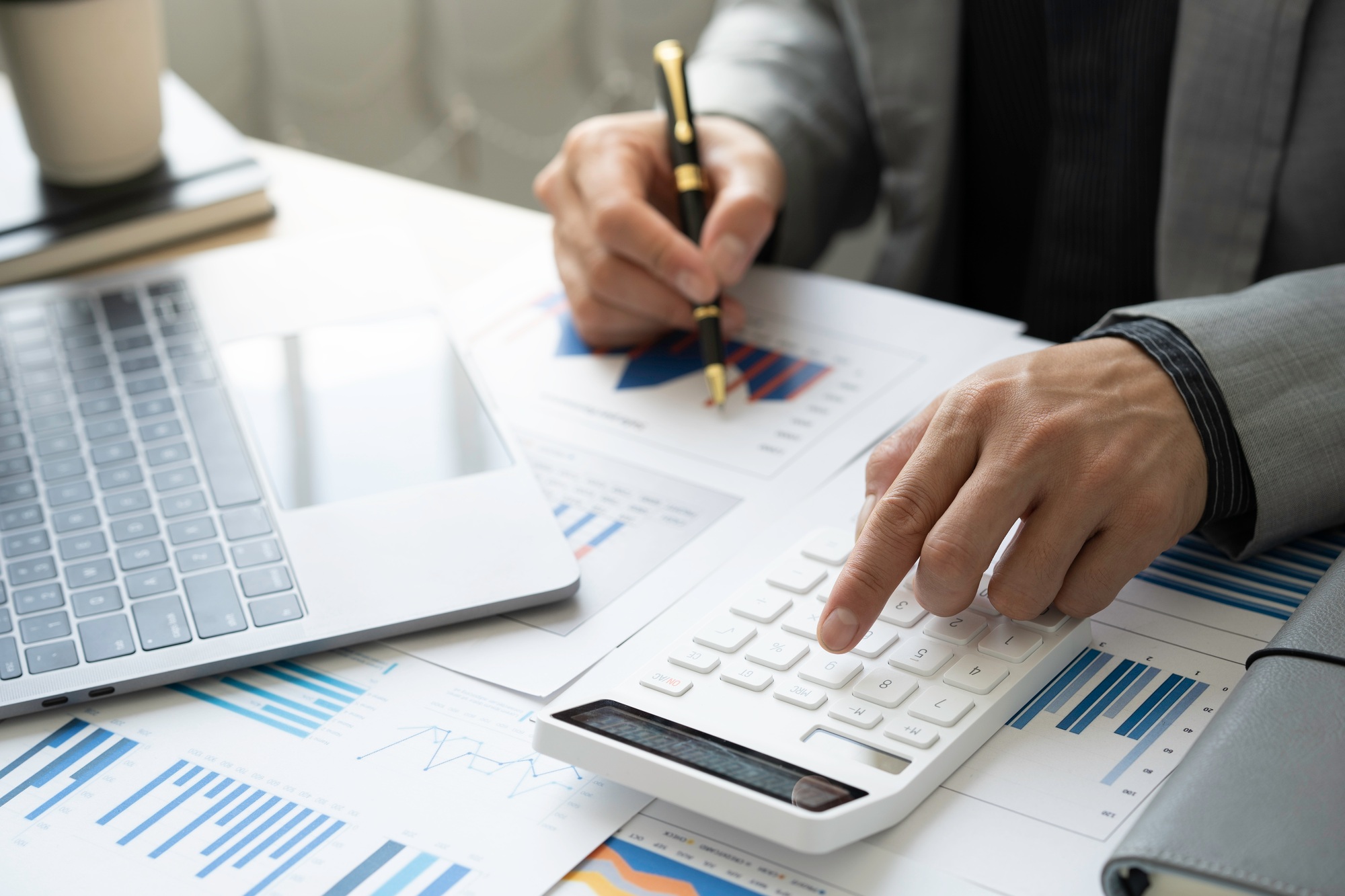 Business accounting concept, Business man using calculator with computer laptop, budget and loan pap